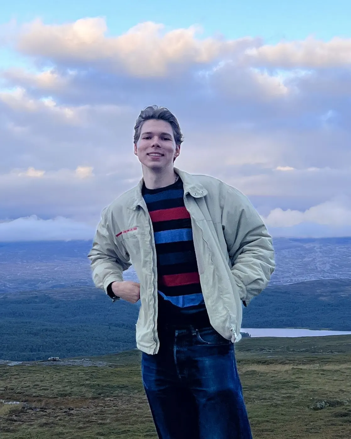 Mikhail Troian smiling outdoors in a light jacket